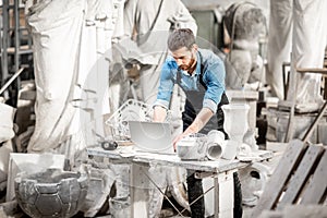 Sculptor working with laptop in the studio