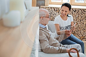 Handsome senior man demonstrating photo to volunteer