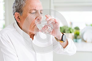 Handsome senior man drinking a fresh glass of water at home