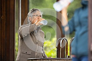 Handsome senior man drinking mineral water in a spa/health resort