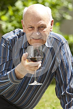 Handsome senior man enjoying a glass of red wine