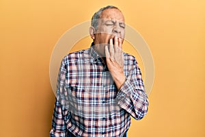 Handsome senior man with grey hair wearing casual shirt bored yawning tired covering mouth with hand