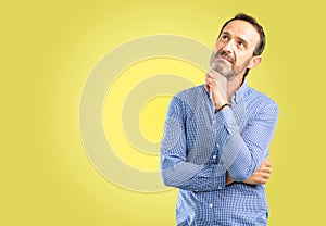 Handsome senior man isolated over yellow background