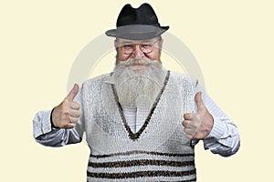 Handsome senior man in sweater shows two thumb up.