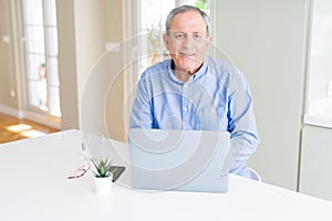 Handsome senior man using laptop and smiling