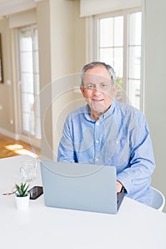 Handsome senior man using laptop and smiling