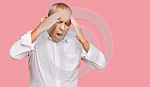 Handsome senior man wearing elegant white shirt with hand on head for pain in head because stress