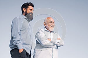 Handsome senior men in blue shirt. Portrait of two bearded men. Grandfather ageing. Male multi generation family walking