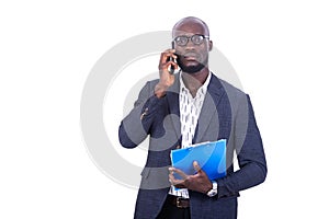 Handsome serious businessman holding clipboard and talking on mobile phone