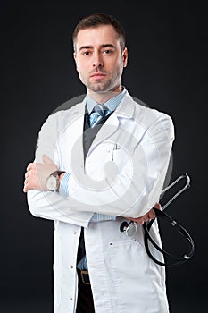 Handsome Serious male doctor holds stethoscope