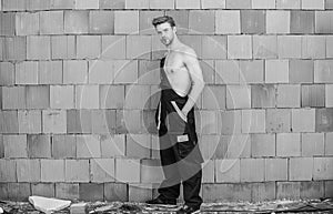 Handsome sexy laborer. Inspecting building. General maintenance repair worker fix maintain building. Worker brick wall