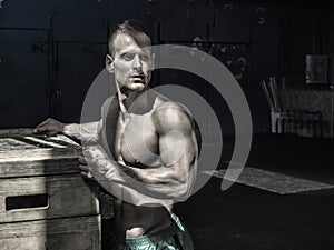 Handsome shirtless muscular man posing in gym