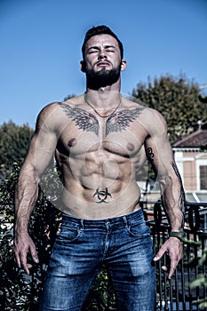 Handsome shirtless muscular young man outdoor