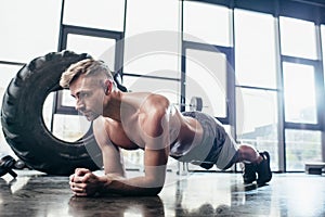 handsome shirtless sportsman doing plank photo