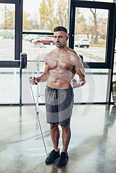 handsome shirtless sportsman training with jumping rope photo