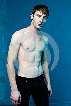Handsome shirtless young man posing in studio