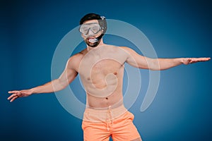 handsome shirtless young man in shorts wearing snorkel and diving mask