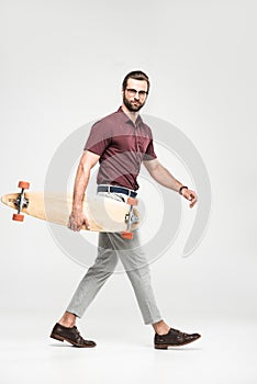 handsome skateboarder posing with longboard,