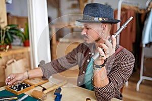 handsome skilled jeweller using instrument for rings repairing