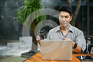 A businessman having an online meeting with his team while remote working at a coffee shop