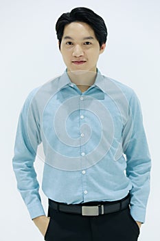 Handsome smiling Asian business man in blue shirt standing with Pick pocket pants arms, on white background. Concept business
