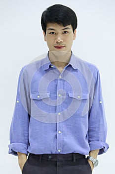 Handsome smiling Asian business man in blue shirt standing with Pick pocket pants arms, on white background. Concept business