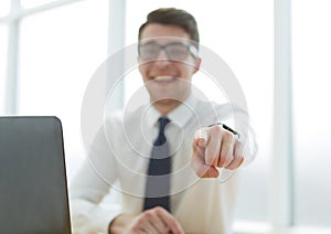 Handsome smiling businessman pointing his finger to you