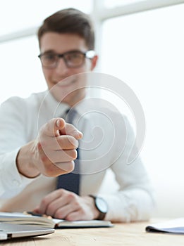 Handsome smiling businessman pointing his finger to you