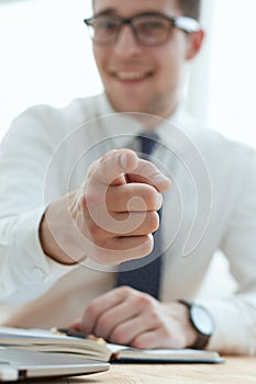 Handsome smiling businessman pointing his finger to you