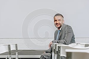 handsome smiling businessman sitting on chair