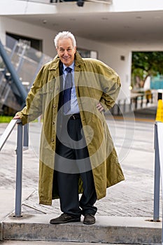 Handsome smiling businessman wearing a trenchcoat over his suit photo