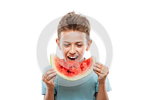 Handsome smiling child boy holding red watermelon fruit slice