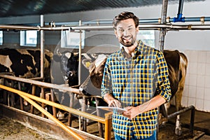 handsome smiling farmer standing with tablet