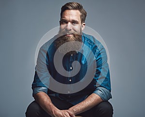 Handsome smiling man in blue shirt and beard