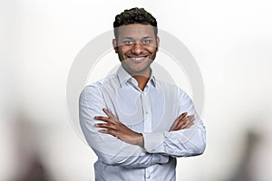 Handsome smiling man with crossed arms looking at camera.