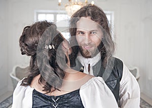 Handsome smiling man in medieval clothes with beautiful woman