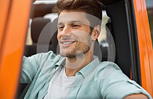 Handsome smiling man sitting on a front seat
