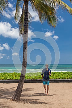 Handsome smiling man standing on the beach