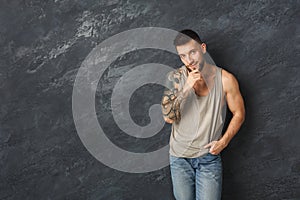 Handsome smiling man with totoos posing in studio