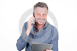 Handsome smiling man using tablet computer using cell phone isolated on white studio background