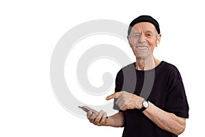 Handsome smiling old man in black t-shirt and hat, stylish senior in white wireless headphones using his phone and