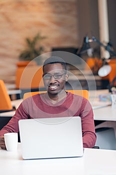 Handsome smiling successful African American man using laptop computer