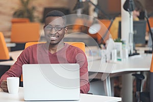 Handsome smiling successful African American man using laptop computer