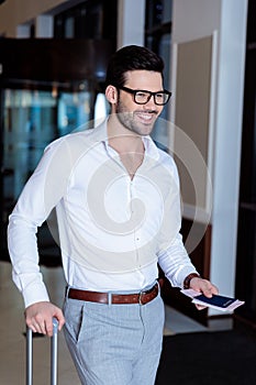 handsome smiling tourist with travel bag