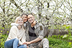 Handsome soldier reunited with family on a sunny day.