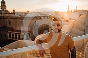 Handsome spanish man enjoying sunset time from a cityscape viewpoint.Having tapas and drinks with a view.Tourist in Seville,