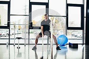 handsome sportive man working out with ropes photo