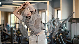 Handsome sportsman warming at gym. Fitness man doing exercises in sport club