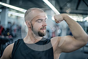 Handsome strong athletic man pumping up muscles workout bodybuilding concept background. Bodybuilder showing muscles, biceps and