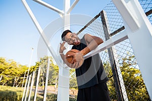 Handsome Strong man is holding ball on the basketball court.Man with a ball,sport outfit,sport competitions